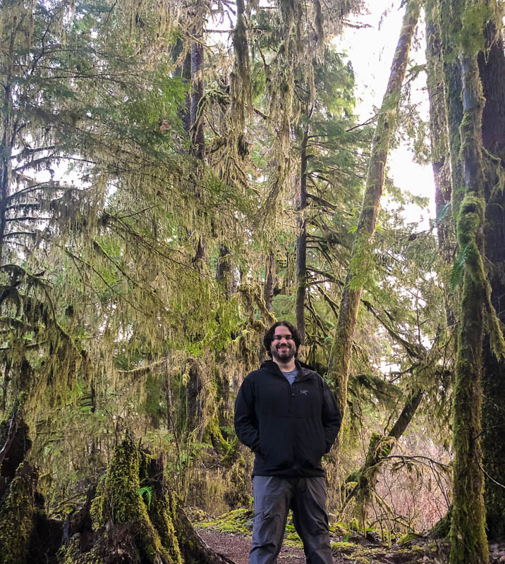 Alex Jeffrey standing in moss-covered rainforest